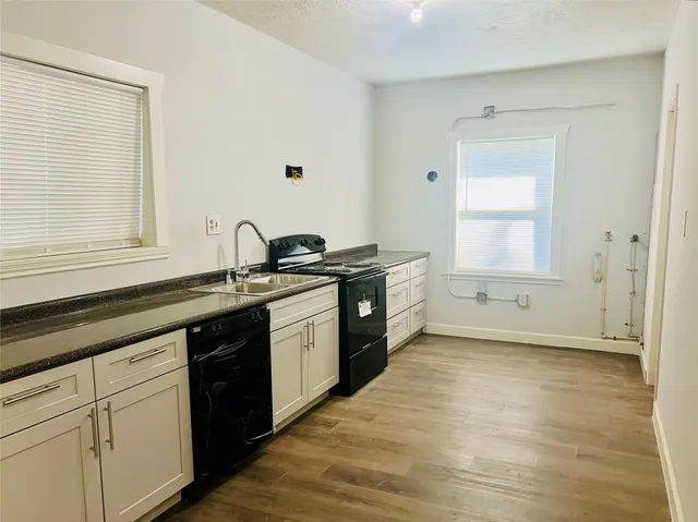 a kitchen with stainless steel appliances granite countertop a sink stove and cabinets