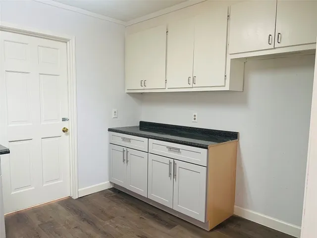 a kitchen with granite countertop white cabinets and sink