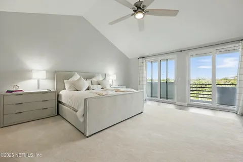a large white bed sitting in a room next to a window