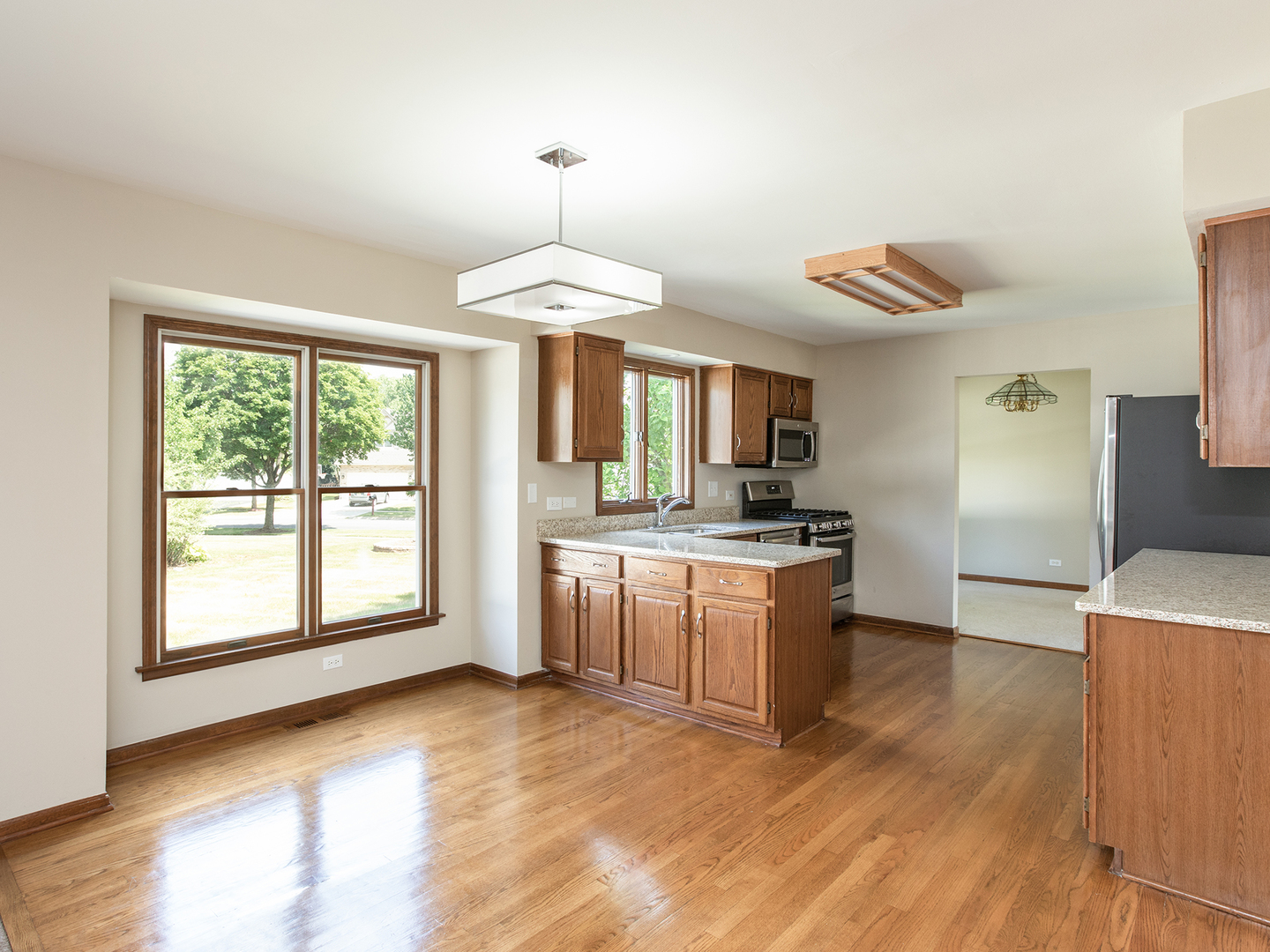872 New Britton Road Carol Stream, IL 60188 - Photo 8 of 22 a kitchen with kitchen island granite countertop a stove a sink and a refrigerator