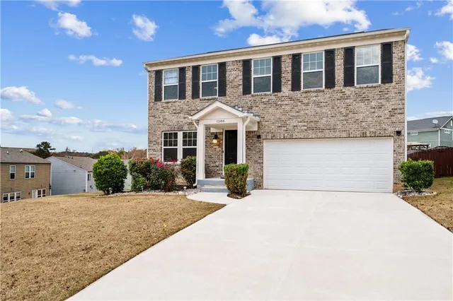 a front view of a house with yard and tress