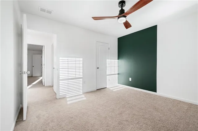 a view of a room with a ceiling fan and window