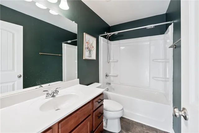 a bathroom with a bathtub shower sink vanity and toilet