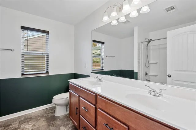 a bathroom with a sink a toilet and a mirror