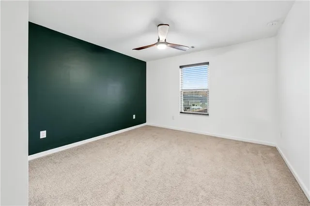 a view of an empty room with a chandelier fan