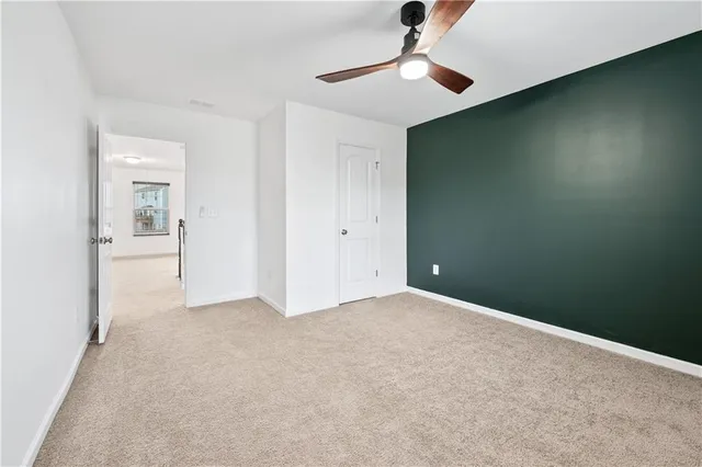 an empty room with closet and a chandelier fan