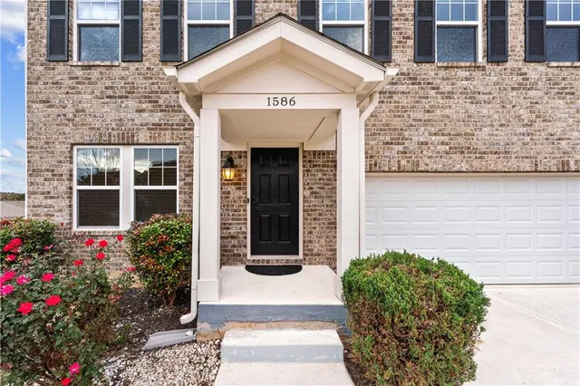 a view of a brick house with potted plants