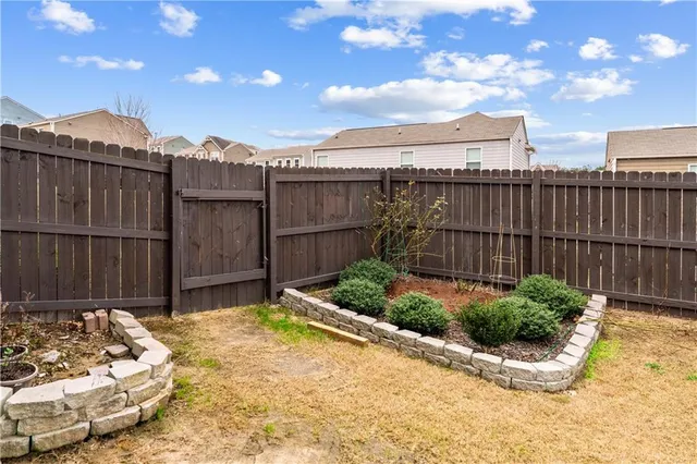 a view of a backyard with a fence and plants
