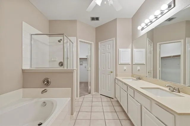a spacious bathroom with a tub a sink and mirrors