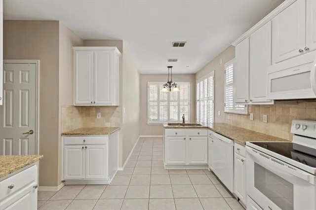 a kitchen with white cabinets appliances and a sink