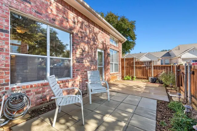 a view of a patio with couple of chairs and potted plants