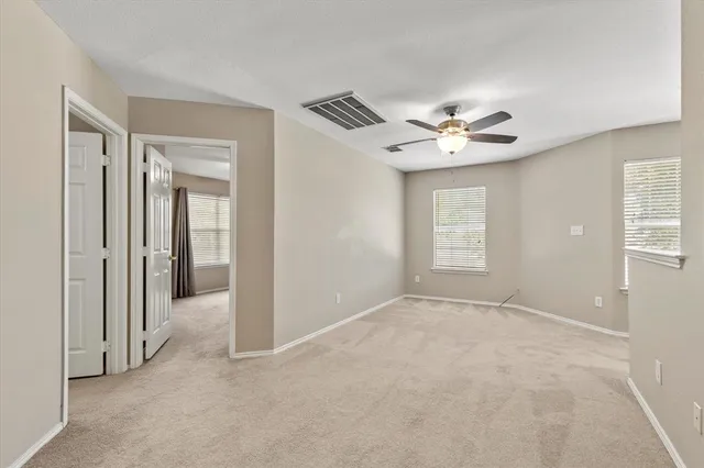 an empty room with fan and windows