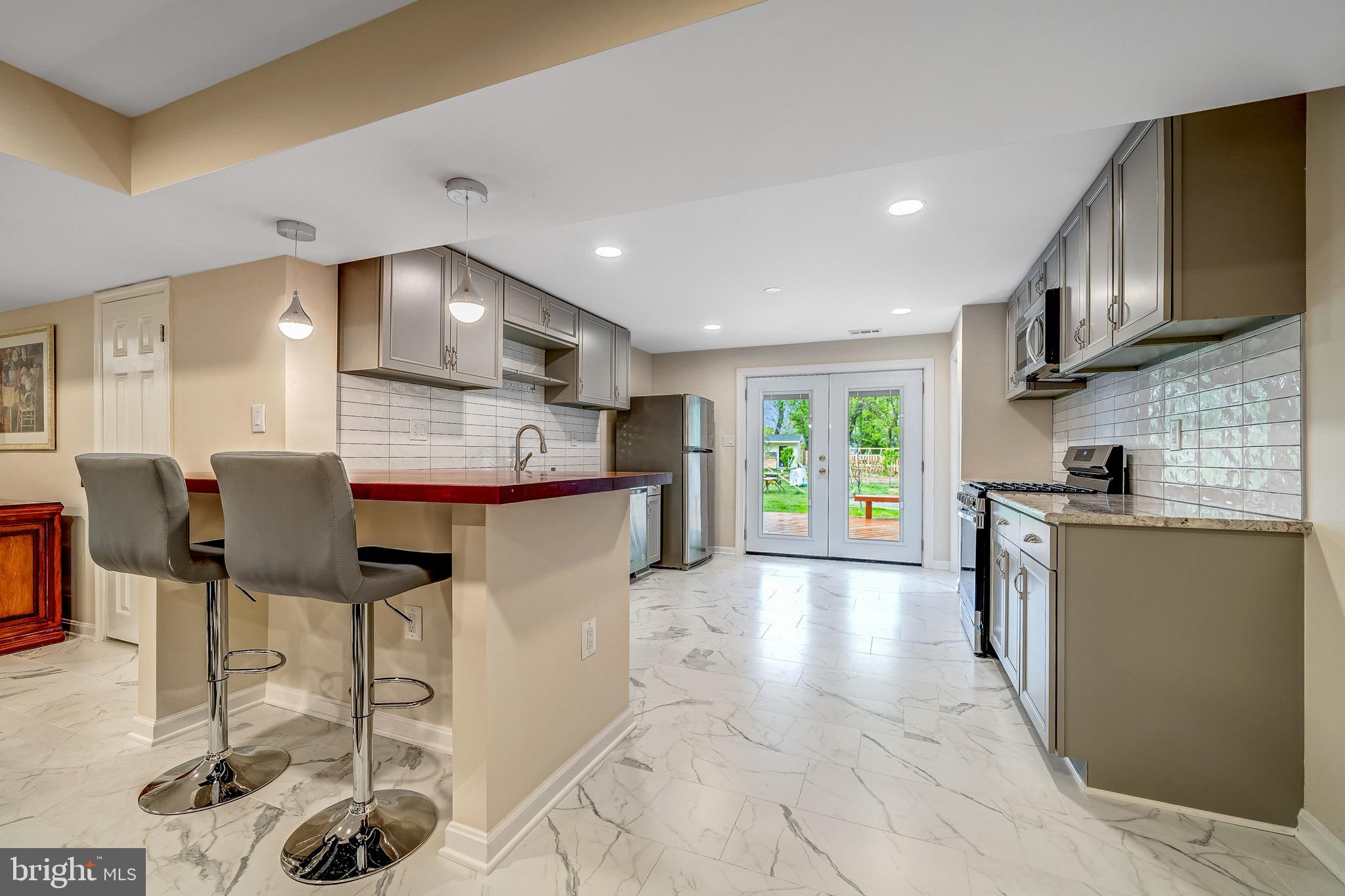 6042 Munson Hill Road Falls Church, VA 22044 - Photo 12 of 30 a open kitchen with stainless steel appliances kitchen island granite countertop a refrigerator and cabinets