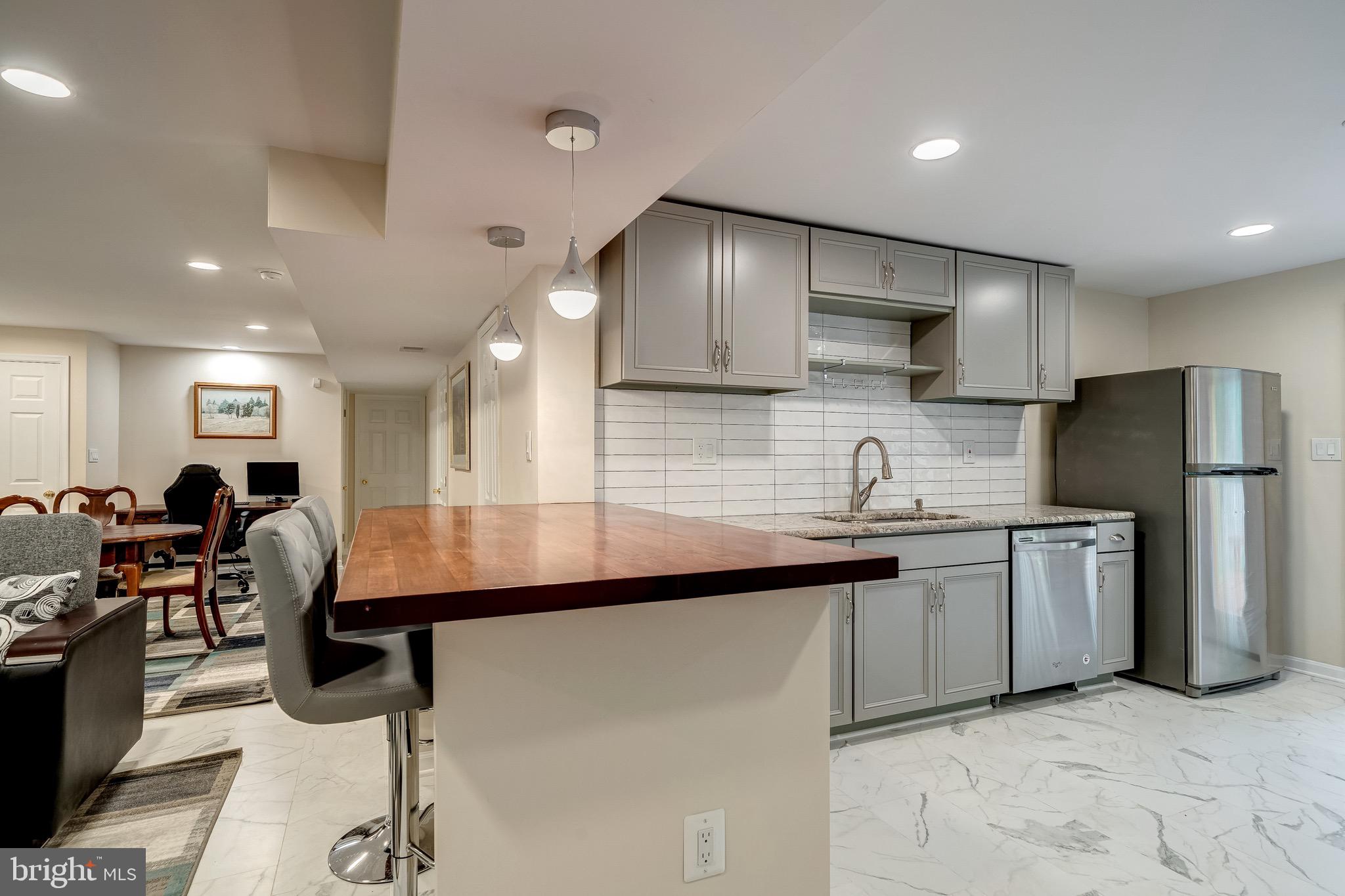 6042 Munson Hill Road Falls Church, VA 22044 - Photo 13 of 30 a kitchen with stainless steel appliances granite countertop a sink refrigerator stove dining table and chairs