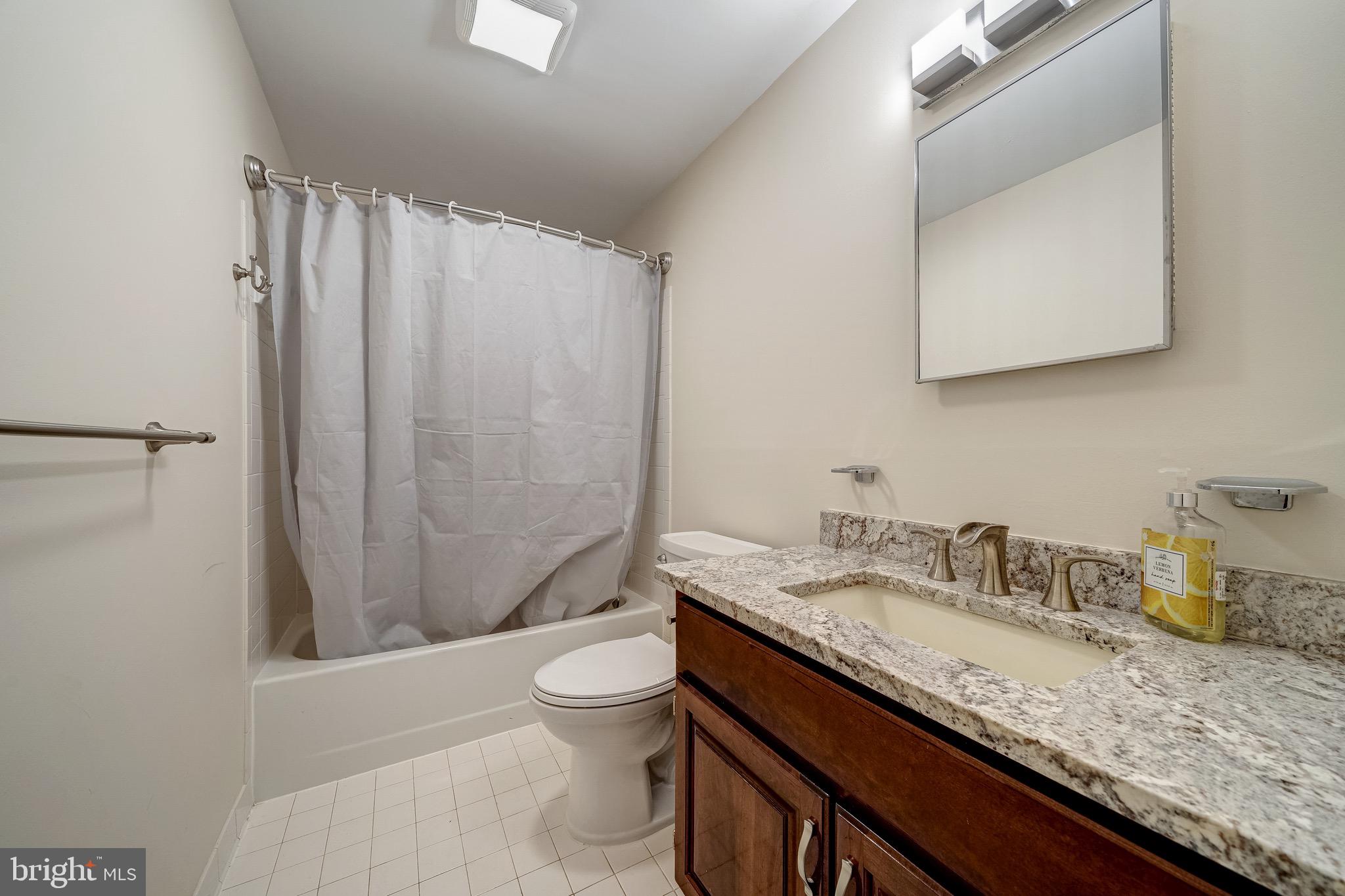 6042 Munson Hill Road Falls Church, VA 22044 - Photo 28 of 30 a bathroom with a granite countertop sink toilet and shower
