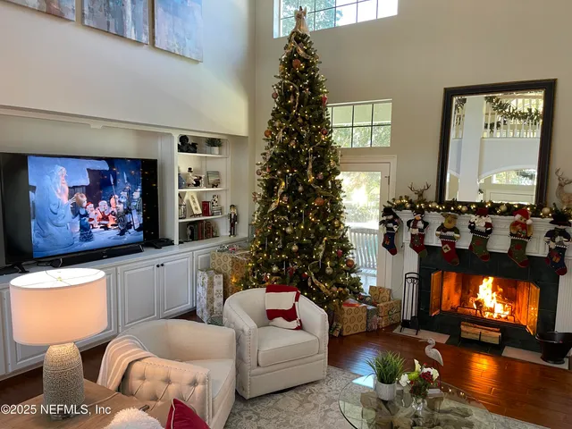 a view of house in front of a big yard with large trees