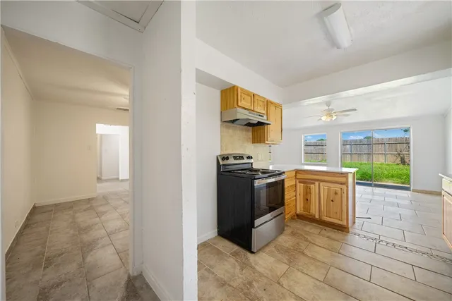 a kitchen with stainless steel appliances granite countertop a stove a sink and a refrigerator