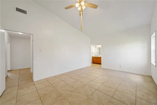 a view of an empty room with a chandelier fan