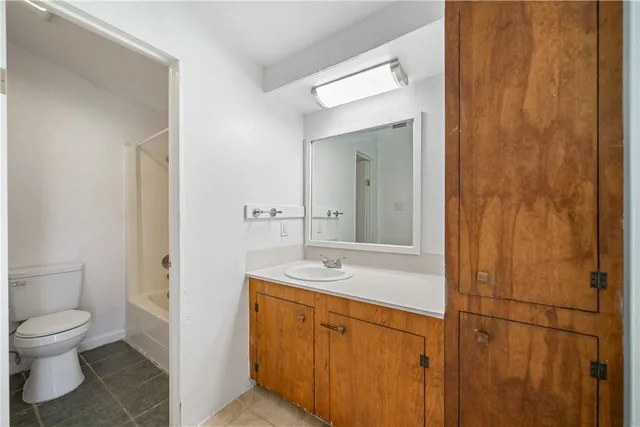 a spacious bathroom with a granite countertop sink a toilet and a mirror