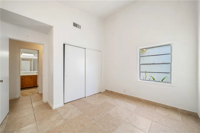 an empty room with windows and closet