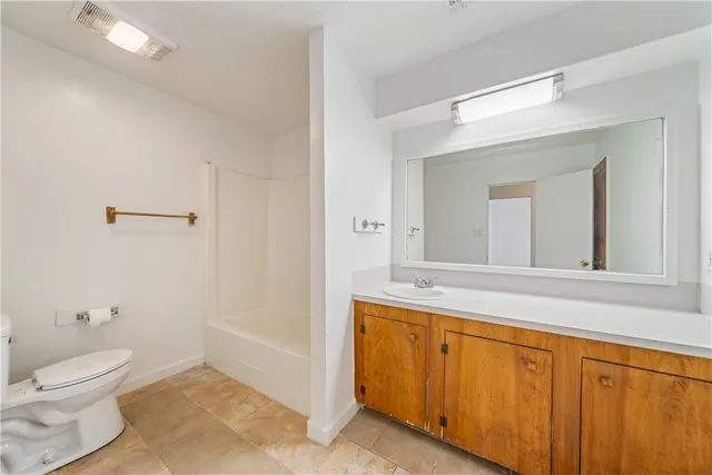 a bathroom with a granite countertop sink mirror vanity and toilet