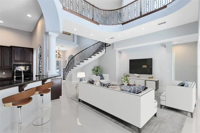 a living room with furniture a flat screen tv and kitchen view