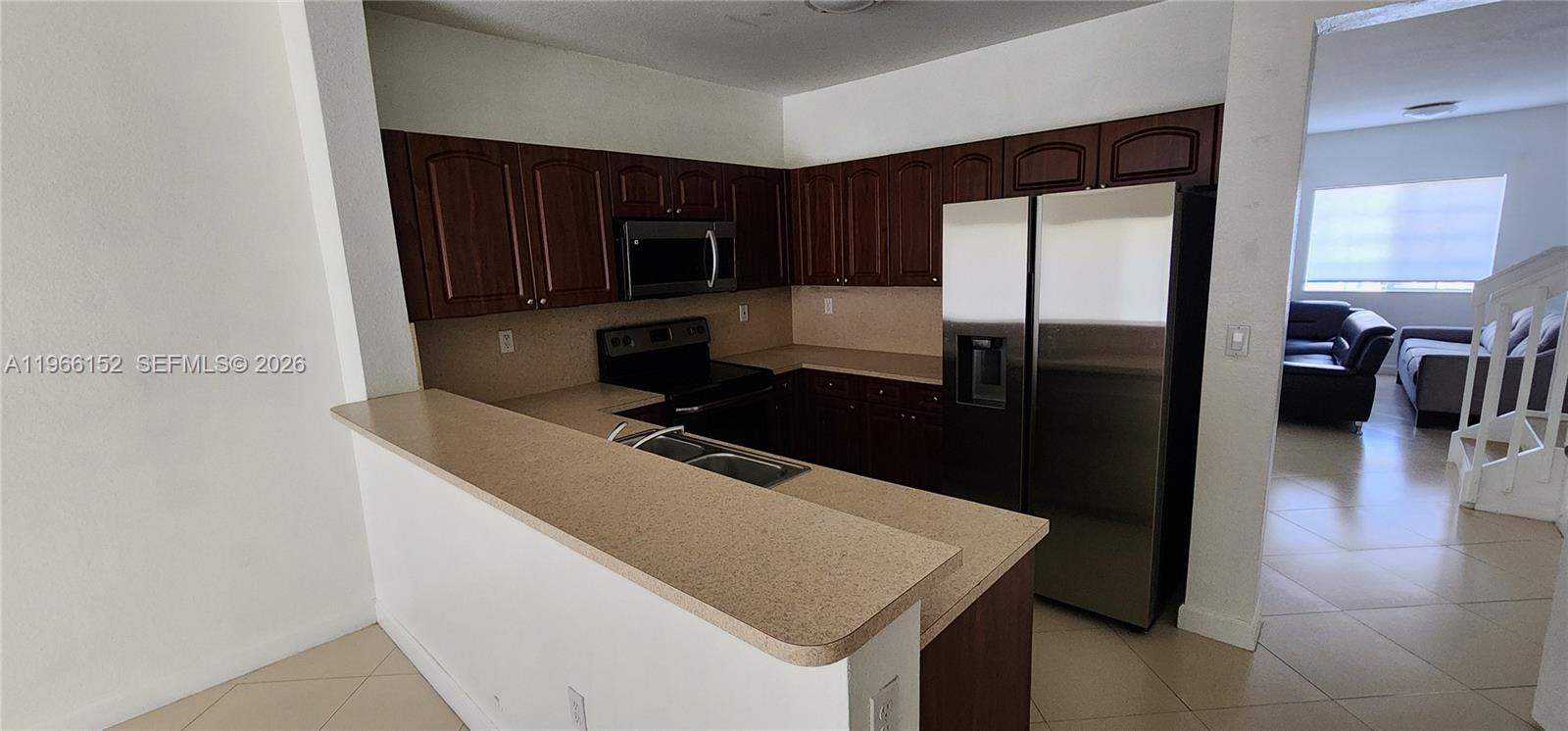 8450 Southwest 150th Avenue, Unit 3 Miami, FL 33193 - Photo 22 of 28 a kitchen with stainless steel appliances granite countertop a refrigerator and a stove top oven