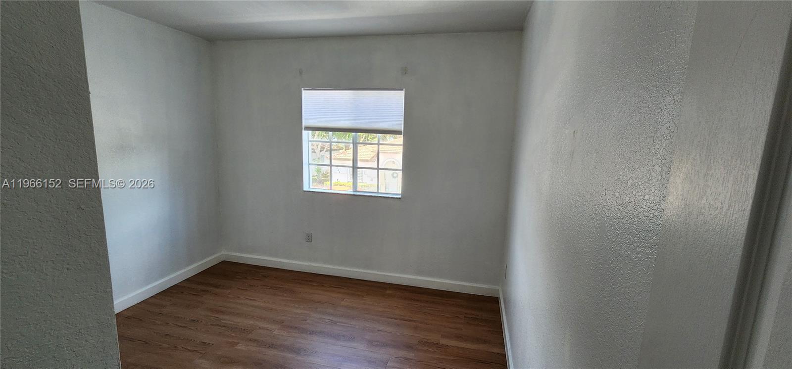 8450 Southwest 150th Avenue, Unit 3 Miami, FL 33193 - Photo 23 of 28 a view of an empty room with wooden floor and a window