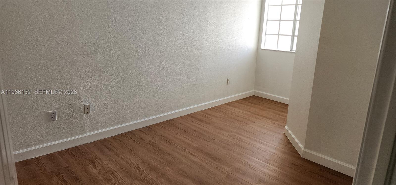 8450 Southwest 150th Avenue, Unit 3 Miami, FL 33193 - Photo 24 of 28 an empty room with wooden floor and windows