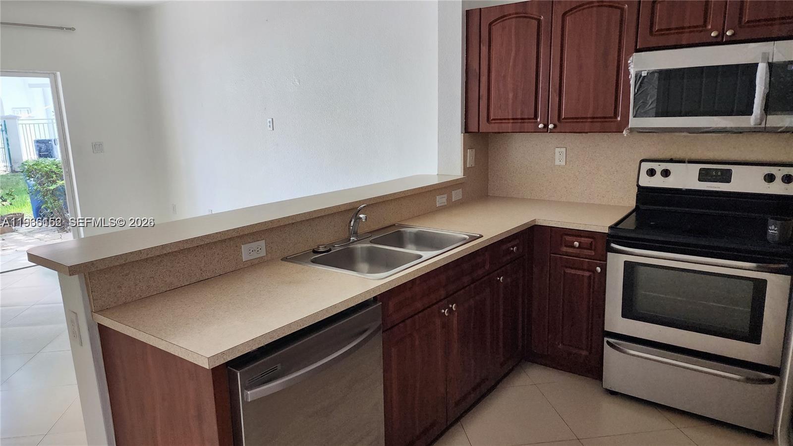 8450 Southwest 150th Avenue, Unit 3 Miami, FL 33193 - Photo 9 of 28 a kitchen with a sink and a stove with wooden floor
