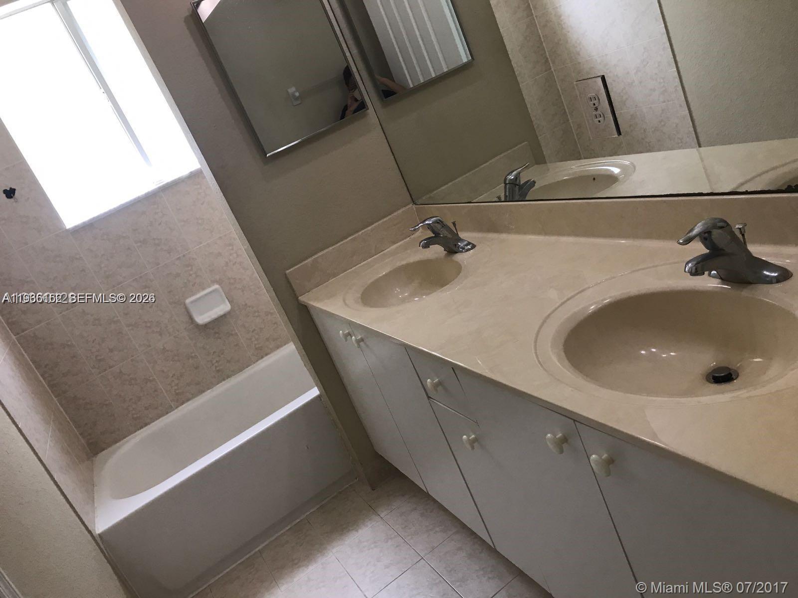 8450 Southwest 150th Avenue, Unit 3 Miami, FL 33193 - Photo 10 of 28 a bathroom with a sink and mirror