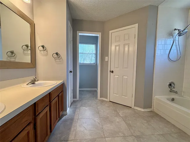 a bathroom with a tub sink and mirror