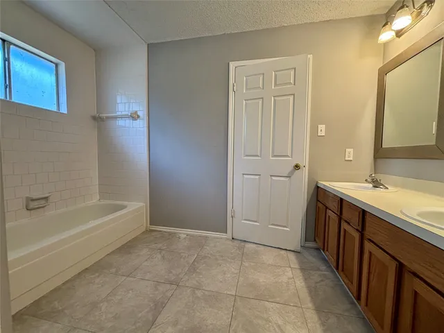 a bathroom with a tub sink and mirror