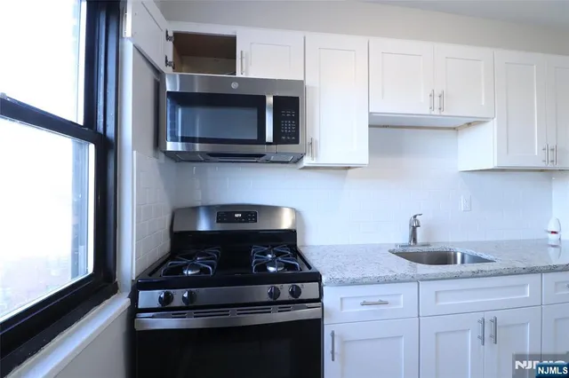 a kitchen with stainless steel appliances a stove and a microwave
