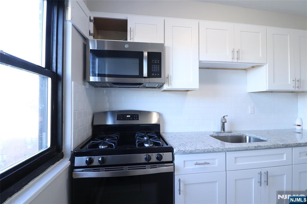 2335 Hudson Terrace, Unit E6 Fort Lee, NJ 07024 - Photo 12 of 29 a kitchen with stainless steel appliances a stove and a microwave