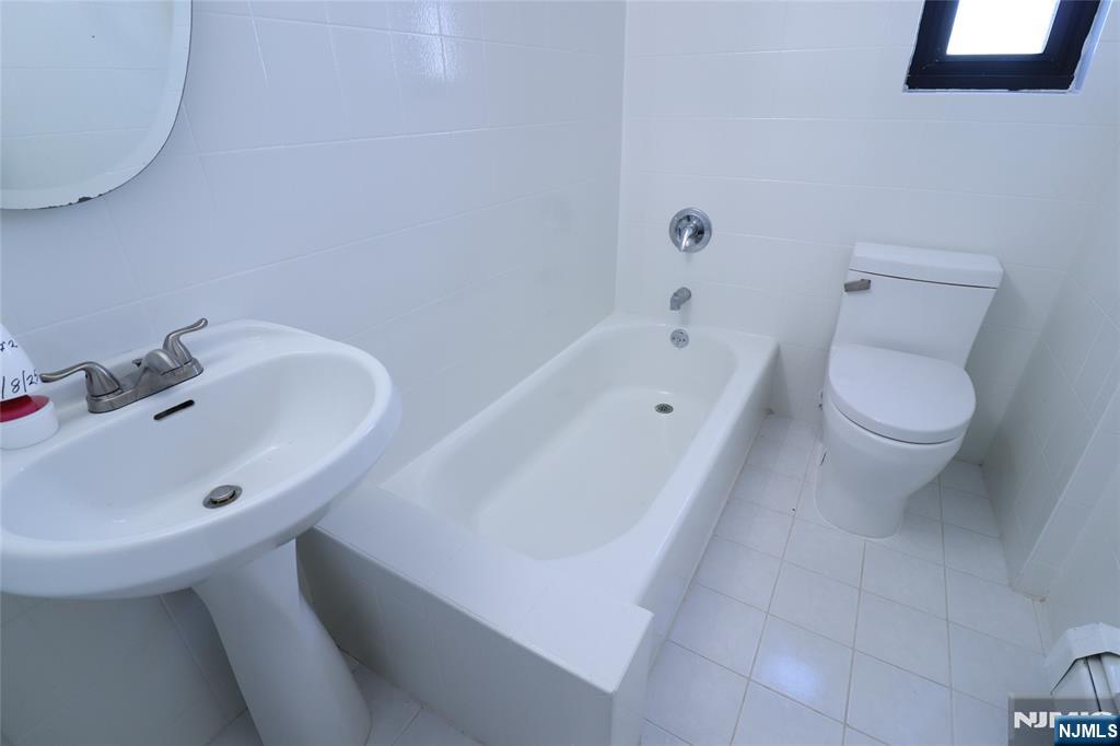 2335 Hudson Terrace, Unit E6 Fort Lee, NJ 07024 - Photo 16 of 29 a bathroom with a sink a toilet and bathtub