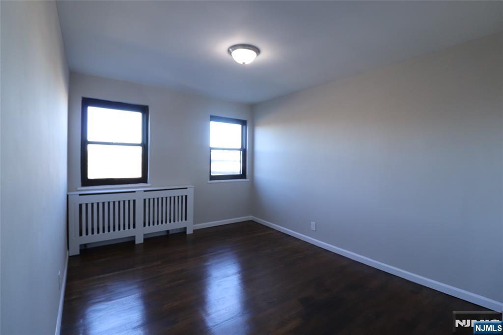 2335 Hudson Terrace, Unit E6 Fort Lee, NJ 07024 - Photo 22 of 29 an empty room with wooden floor and windows