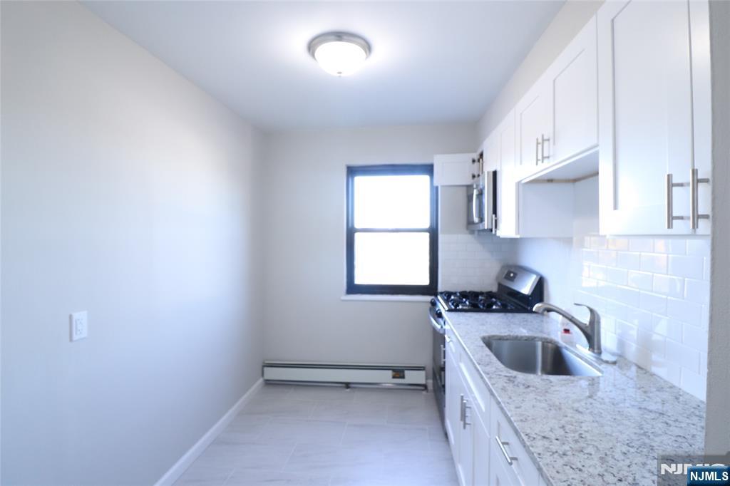 2335 Hudson Terrace, Unit E6 Fort Lee, NJ 07024 - Photo 9 of 29 a kitchen that has a sink a stove and cabinets