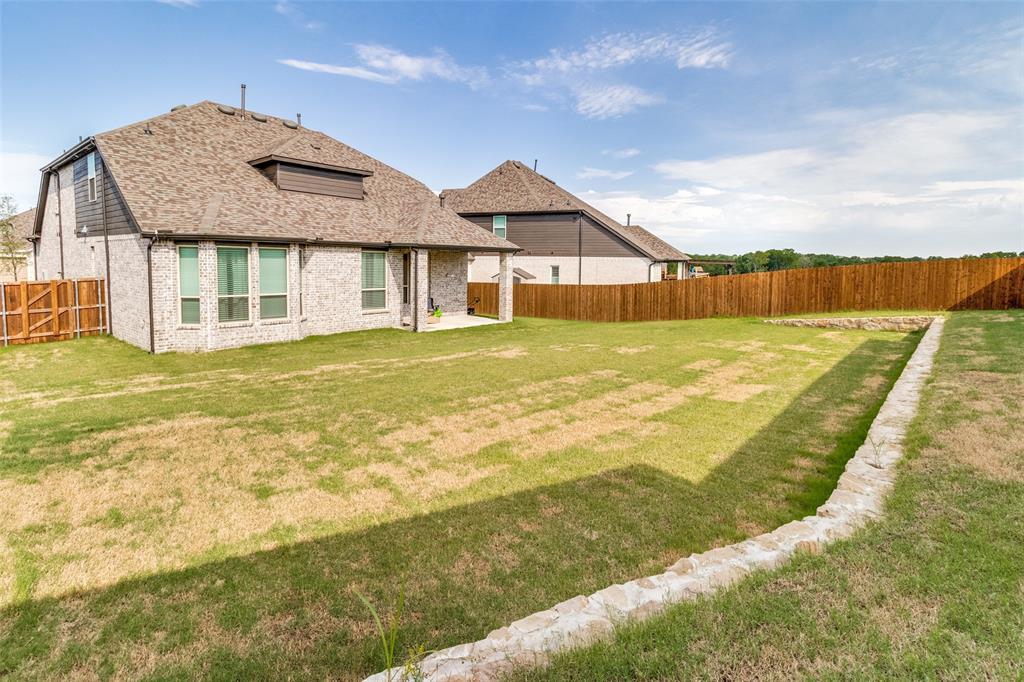 503 North Eagle Pt Road Van Alstyne, TX 75495 - Photo 24 of 25 Back of house with a shingled roof, a patio, a fenced backyard, and brick siding