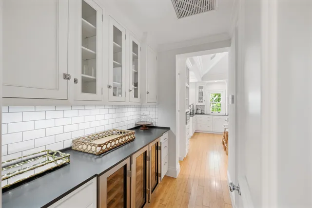 a kitchen with stainless steel appliances granite countertop a stove a sink dishwasher a dining table and chairs with wooden floor