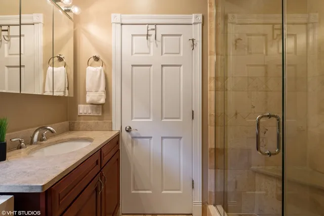 a bathroom with a granite countertop sink a mirror and a shower