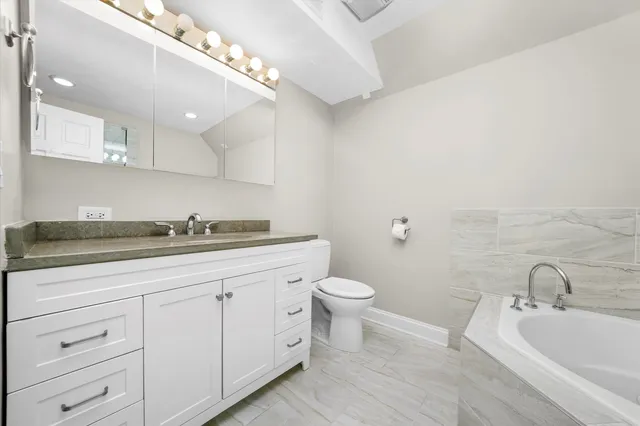 a spacious bathroom with a toilet a sink and mirror