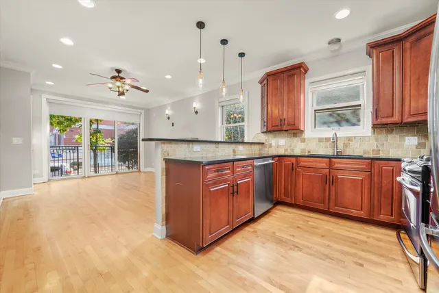 a large kitchen with stainless steel appliances granite countertop a stove a sink dishwasher and a large refrigerator