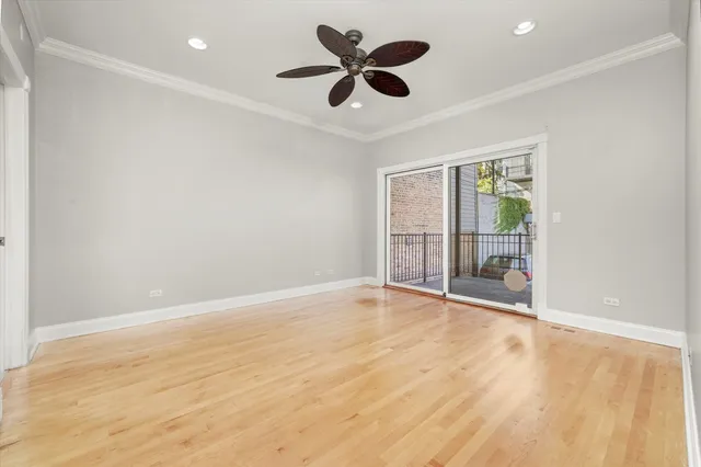 an empty room with chandelier fan and windows