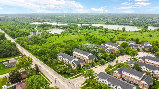 an aerial view of a house with a yard and green space