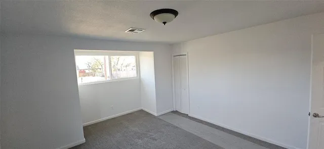 an empty room with windows and wooden floor