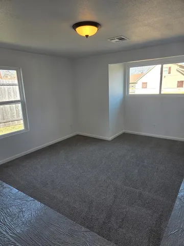 an empty room with windows and closet