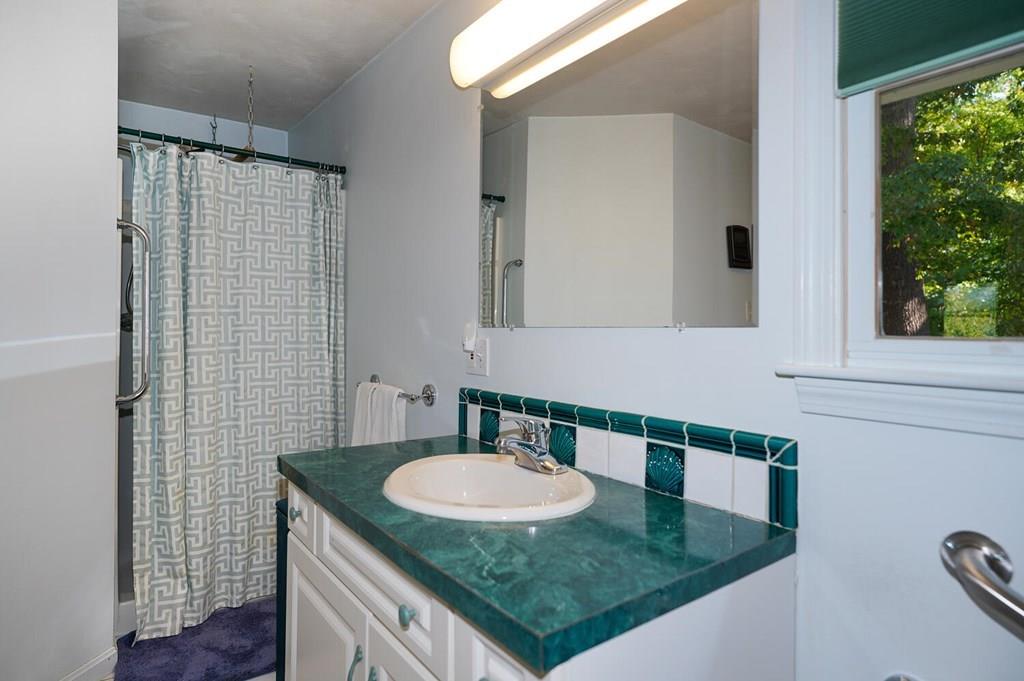 230 Simpson Road Marlborough, MA 01752 - Photo 20 of 32 a bathroom with a granite countertop sink a mirror and a shower