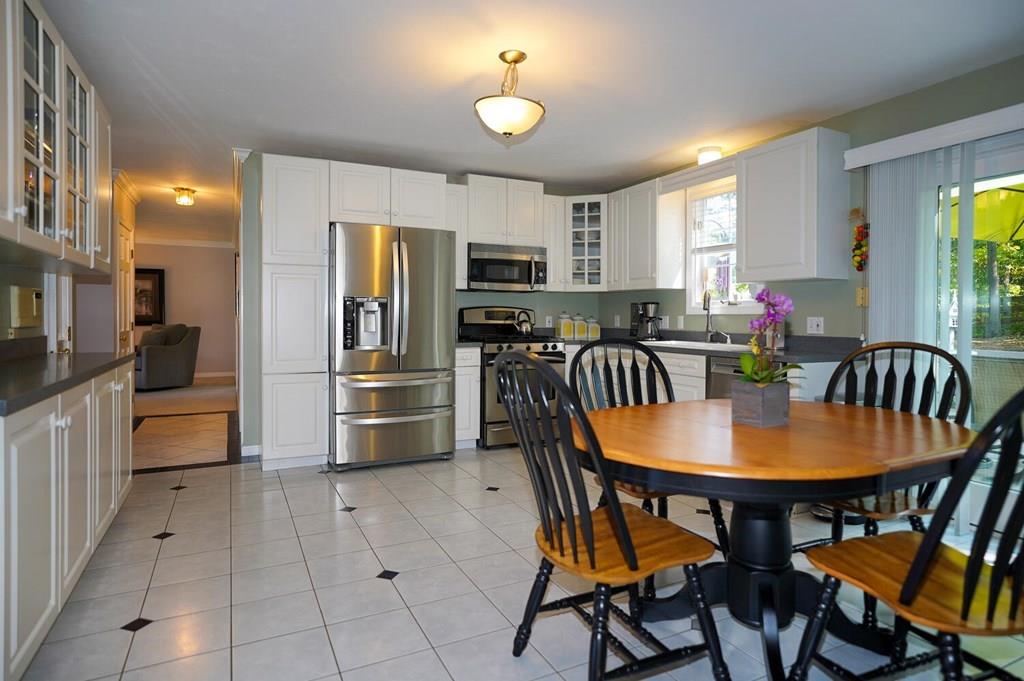 230 Simpson Road Marlborough, MA 01752 - Photo 4 of 32 a kitchen with stainless steel appliances granite countertop a stove a refrigerator a kitchen island a dining table and chairs