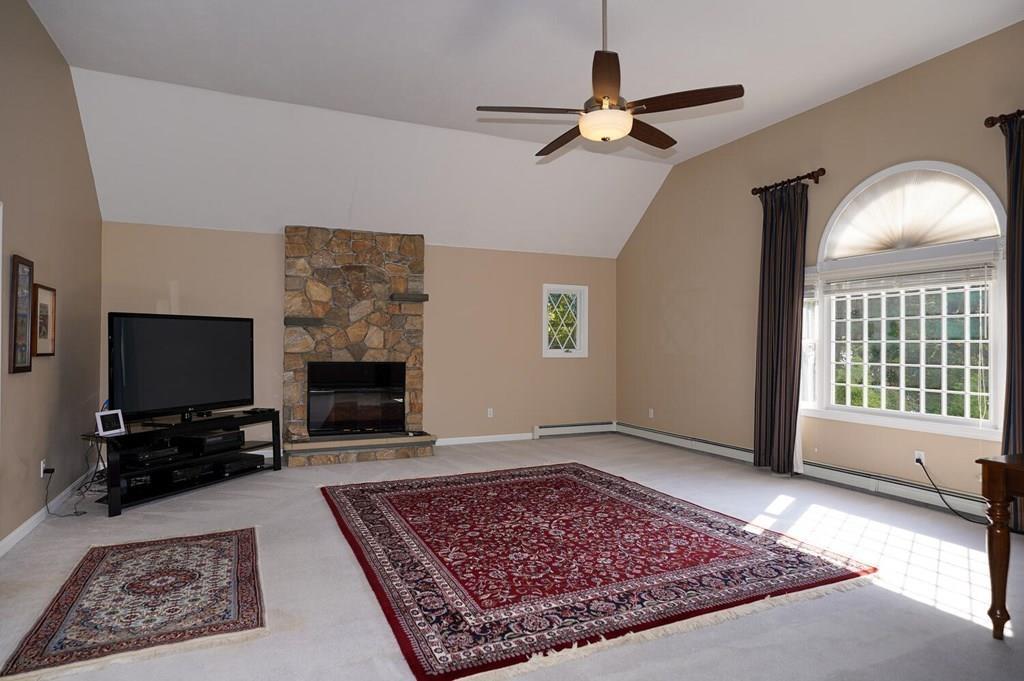 230 Simpson Road Marlborough, MA 01752 - Photo 8 of 32 a living room with a couch a rug and a flat screen tv